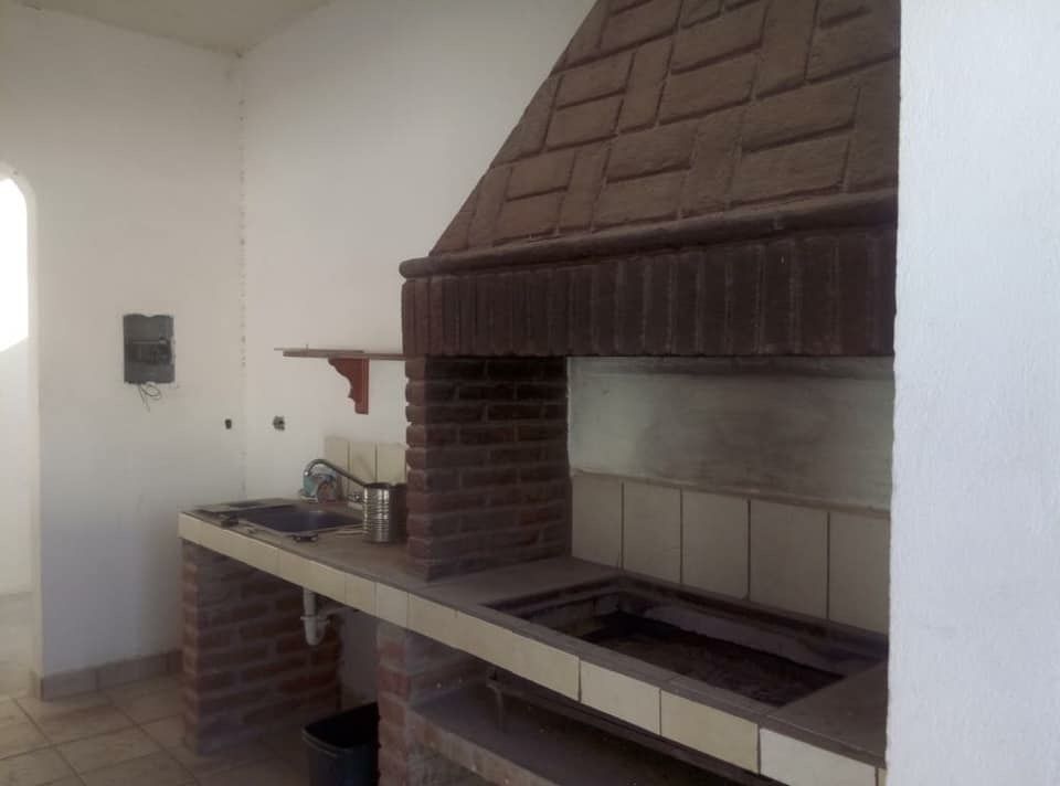 4 de 10: Área de cocina, con asador, tarja, y barra.