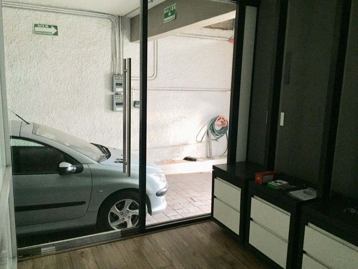 13 of 29: ingreso al área de oficinas por puerta cristal