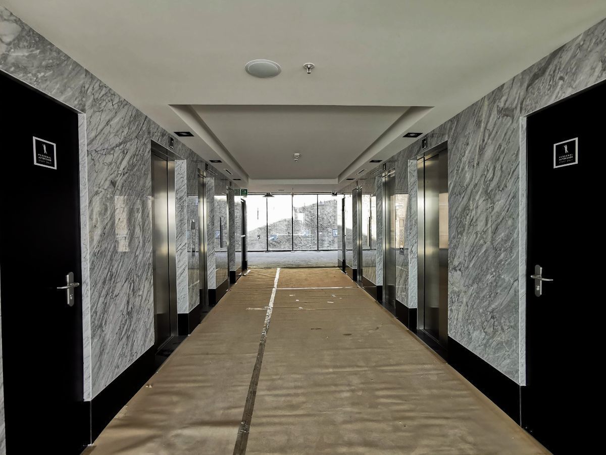 9 de 19: Pasillo de oficinas con baños y elevadores