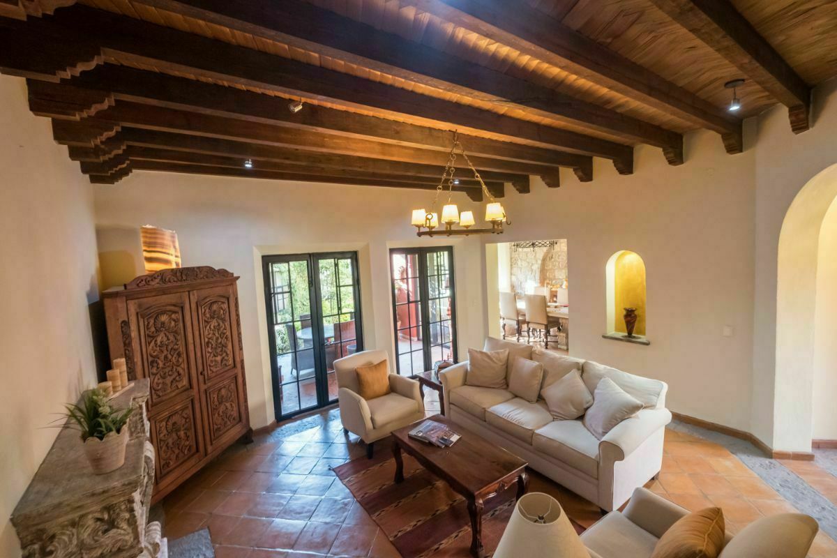 4 de 30:  Sala con chimenea y techo de tejamanil con vigas en madera.