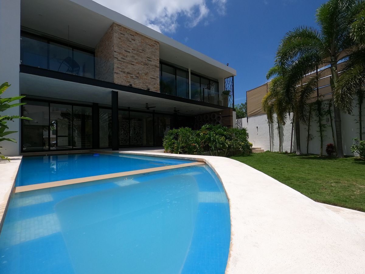 18 de 47: Amplia piscina con jardín y terraza techada en residencia