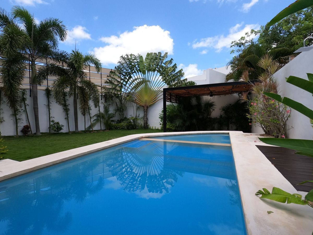 21 de 47: Amplia piscina con jardín y terraza techada en residencia