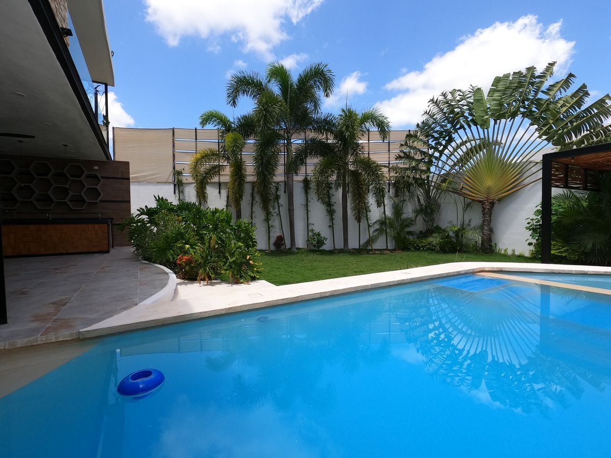 23 de 47: Amplia piscina con jardín y terraza techada en residencia
