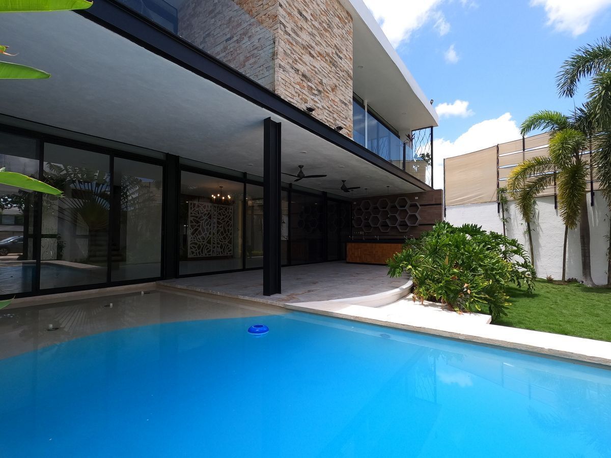 24 de 47: Amplia piscina con jardín y terraza techada en residencia