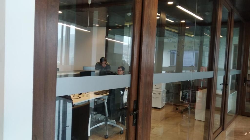 3 de 15: Oficinas divididas con perfiles de madera y grandes vidrios.