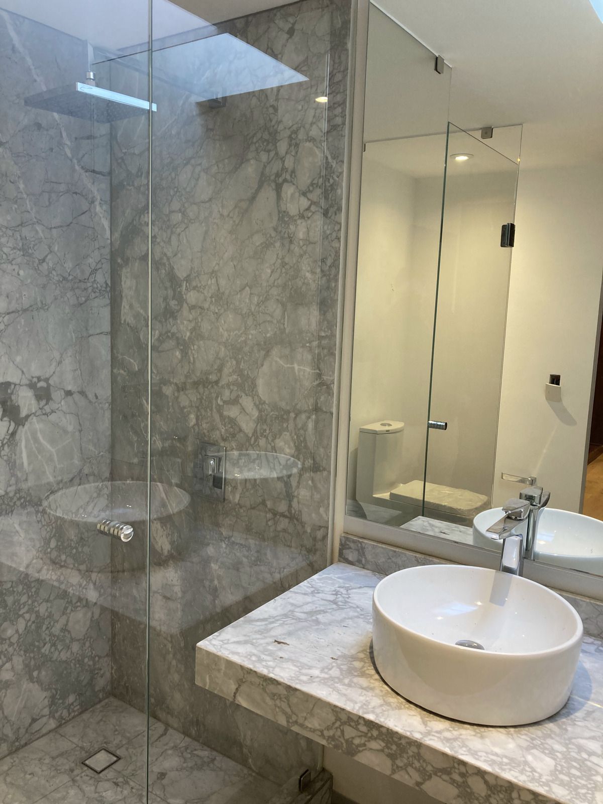 BAÑO CON MARMOL Y CANCELES DE CRISTAL TEMPLADO