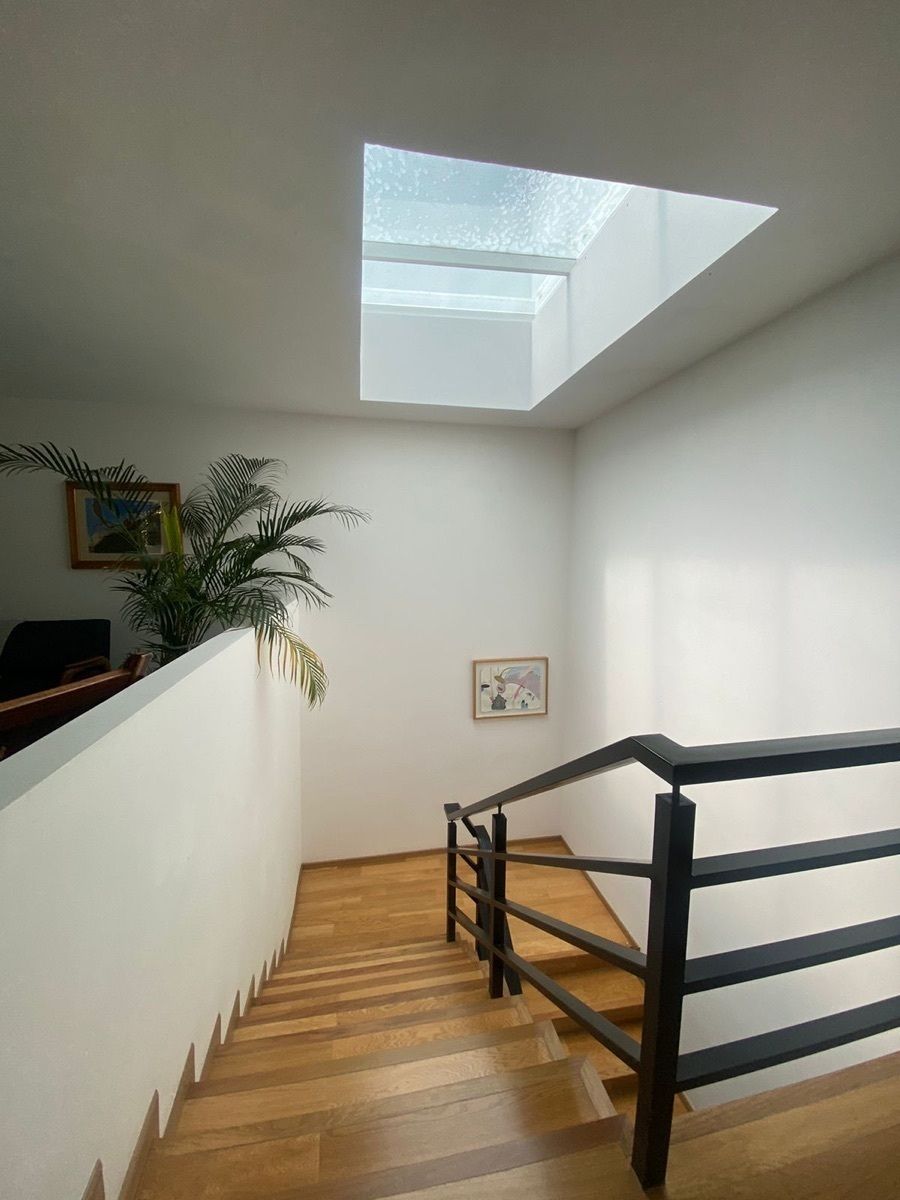 3 de 6: Escaleras de madera con barandal de acero. Entrada de luz.