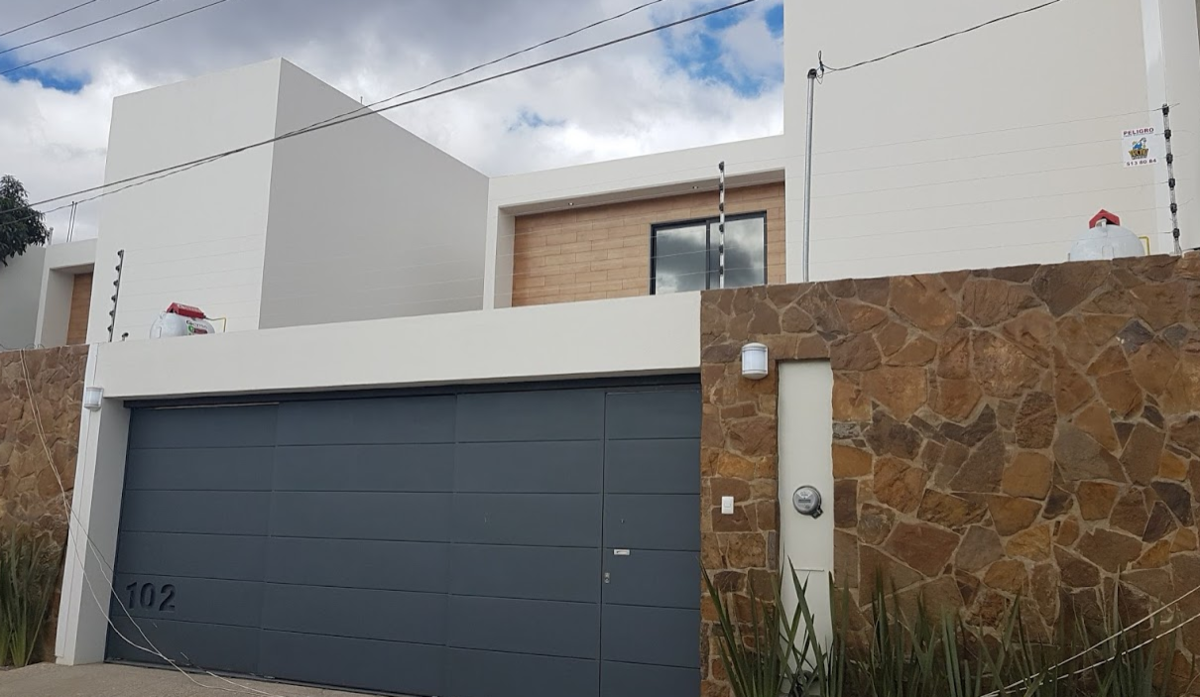 1 de 18: Fachada con portón automatizado para dos vehículos
