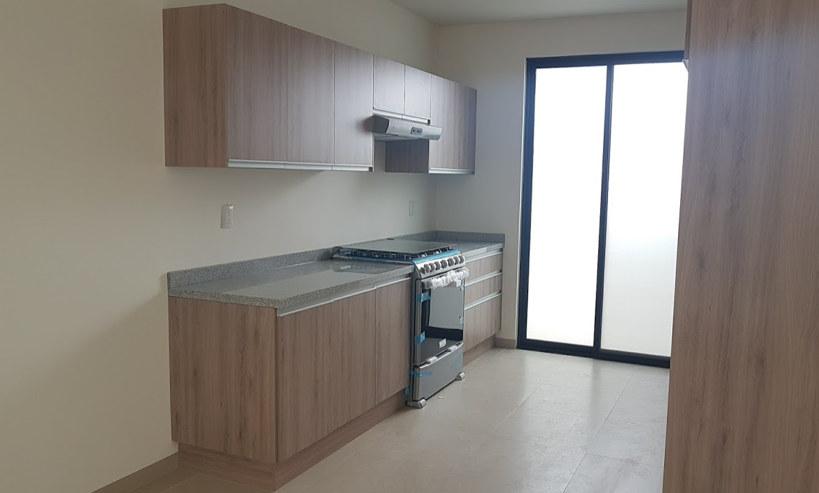 4 de 18: Cocina con estufa y campana y  puerta hacia patio servicio