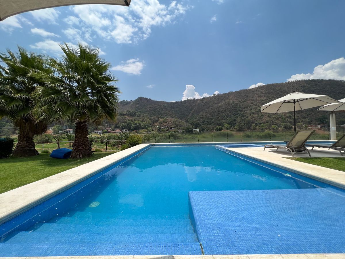 3 de 25: Área de alberca con jacuzzi y tumbonas
