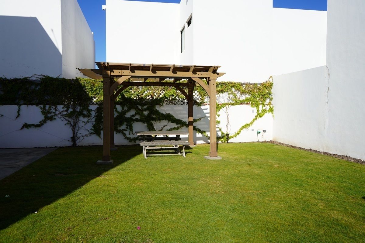9 de 15: Amplio jardín con pérgola y mesa de patio