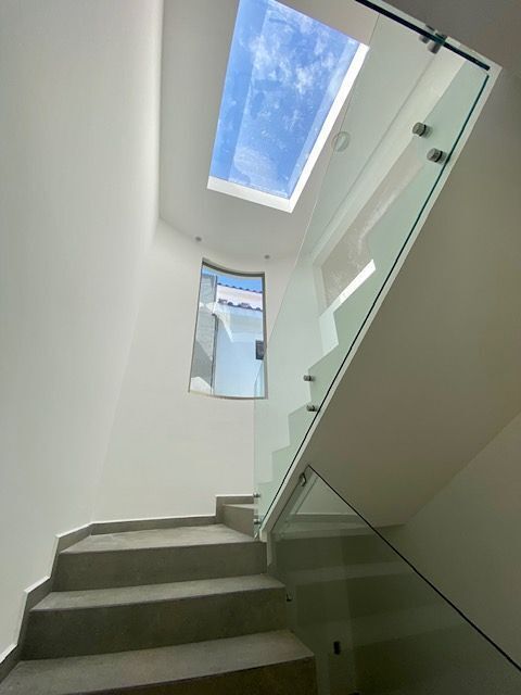 14 de 29: Escaleras forradas de cantera con barandal de cristal.