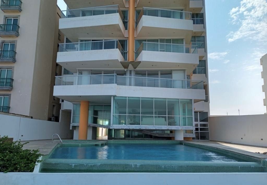 12 of 21: Alberca trasera y sala con vista al mar