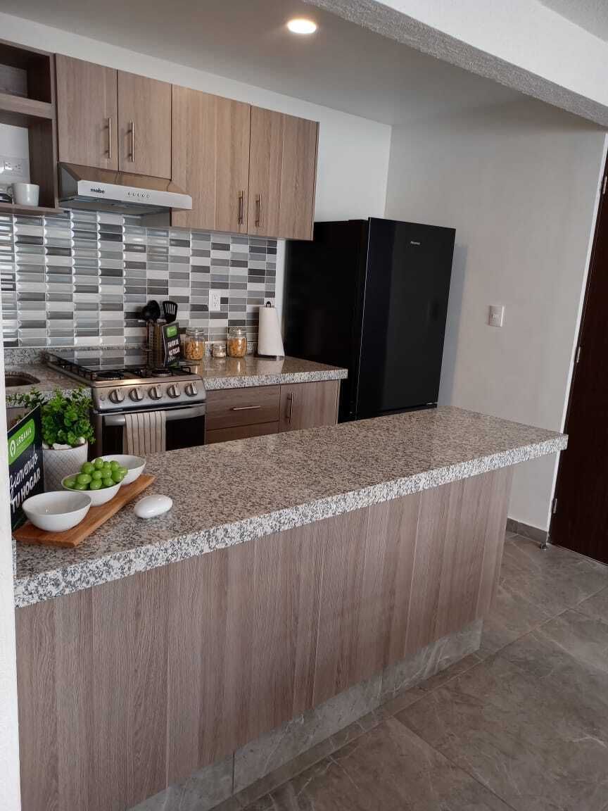 4 de 13: Cocina equipada con estufa y campana de extracción.