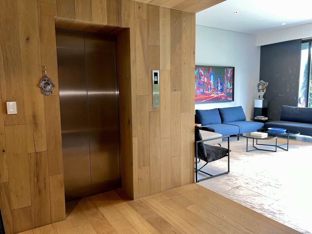 6 of 36: Elevador directo a precioso recibidor cubierto de madera