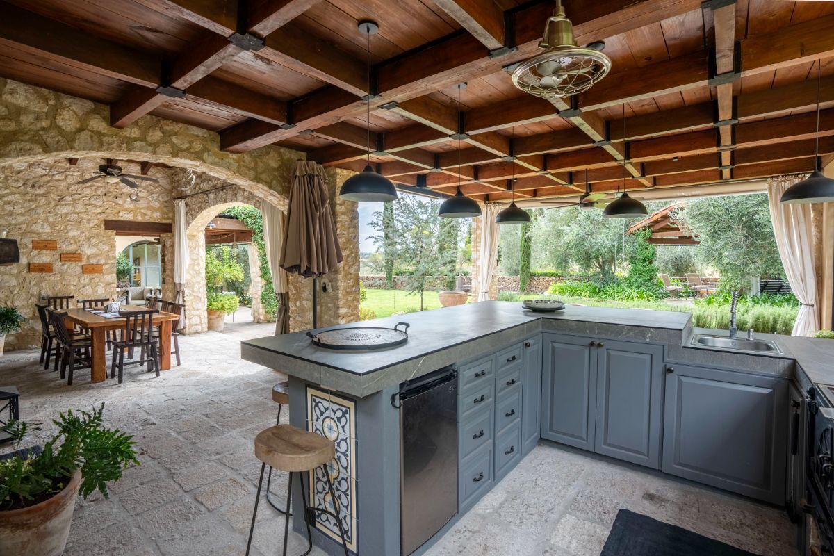 cocina exterior con asador de leña, gas y weber green egg
