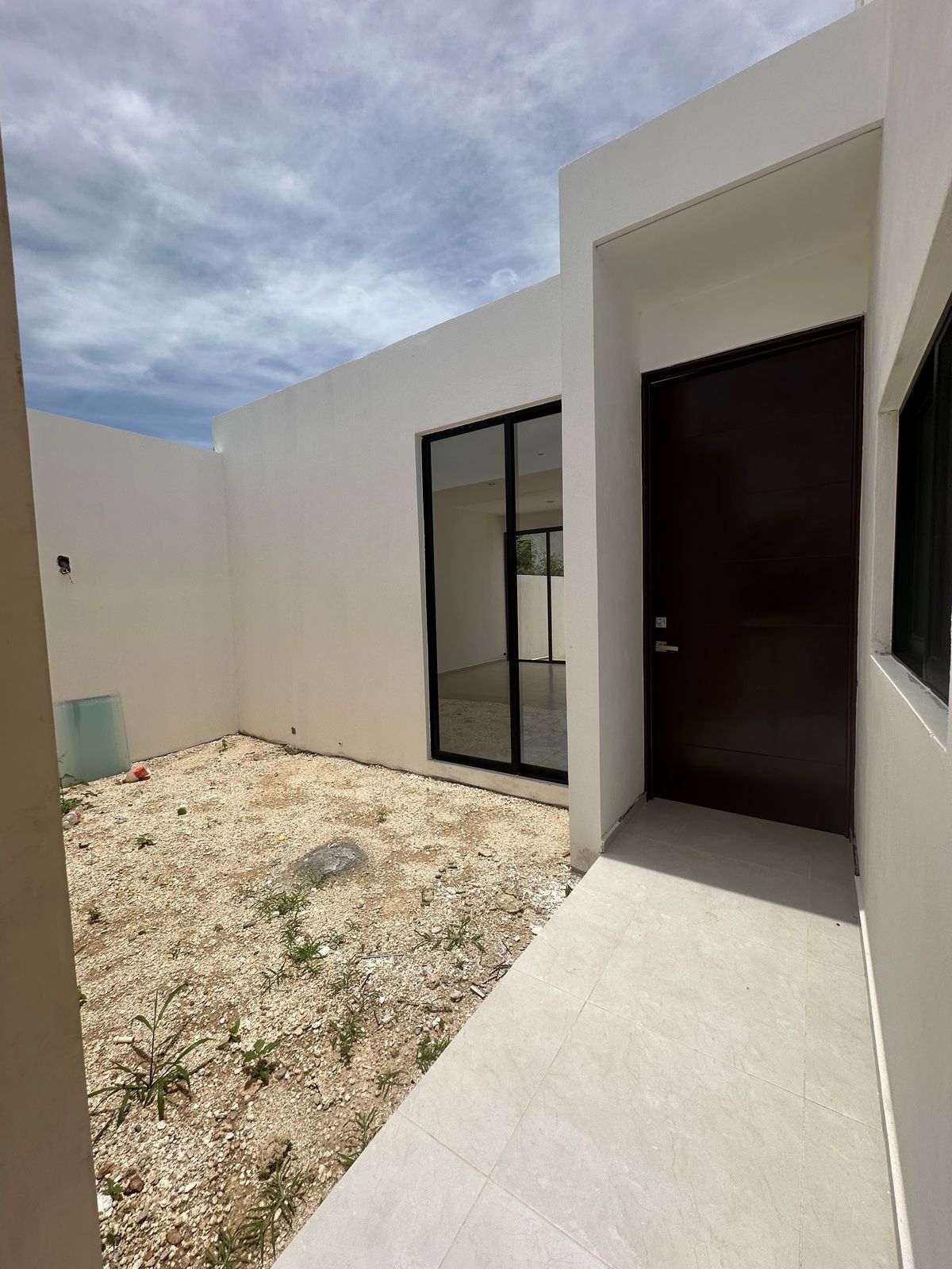 2 of 13: Puerta principal con área de jardin