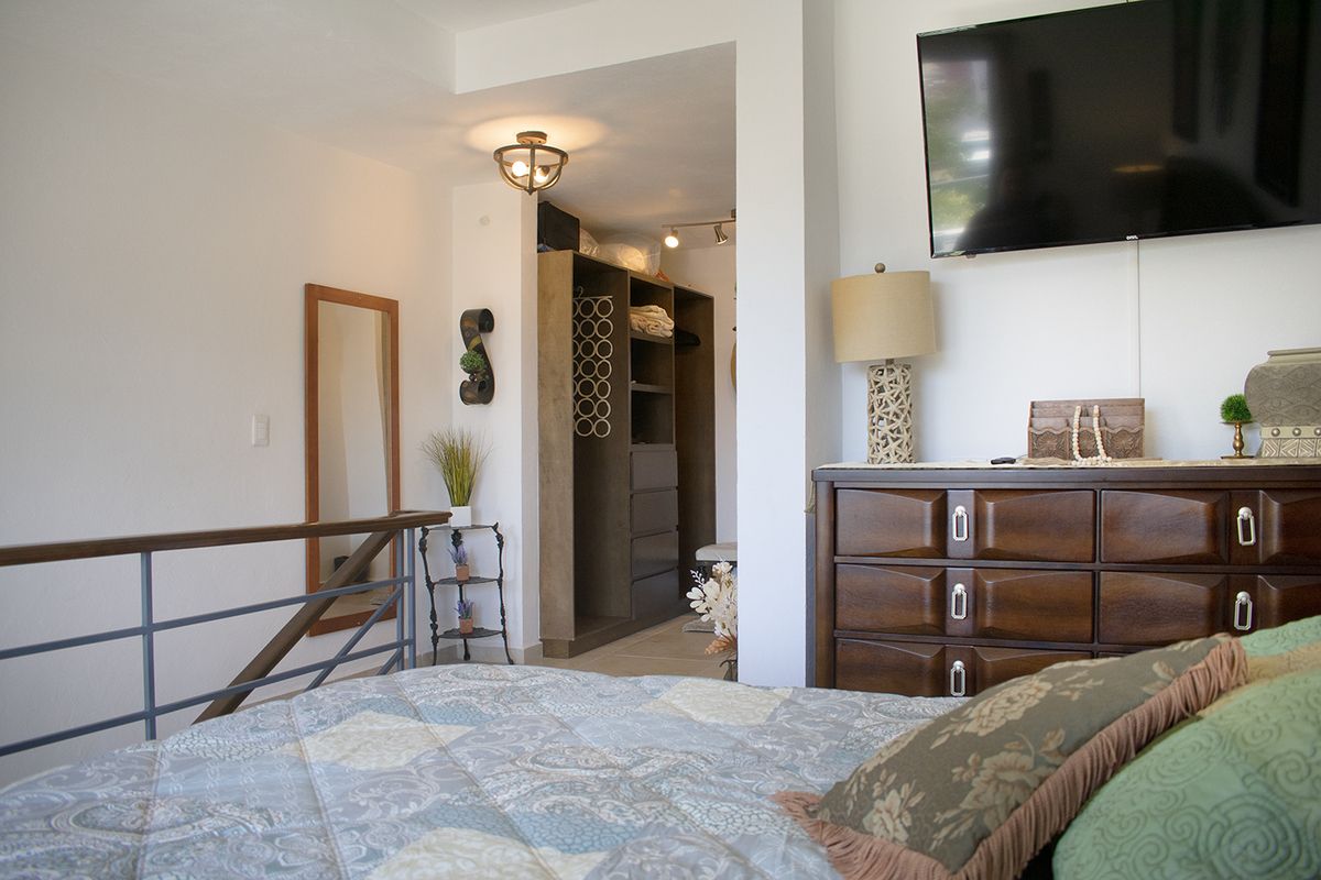 24 de 37: Main bedroom with TV, dresser, and walk-in closet view
