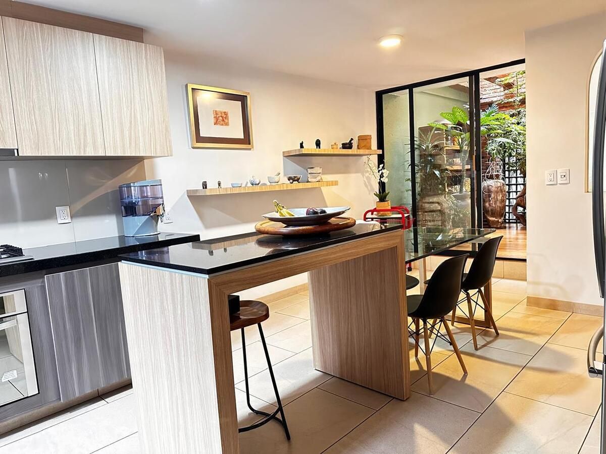 9 of 20: Cocina con barra central y acceso a comedor