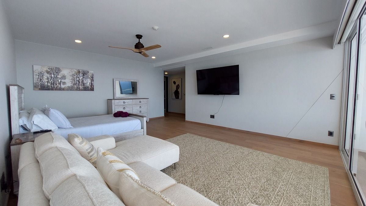 18 de 38: Primary bedroom with ocean view, sitting area, and TV
