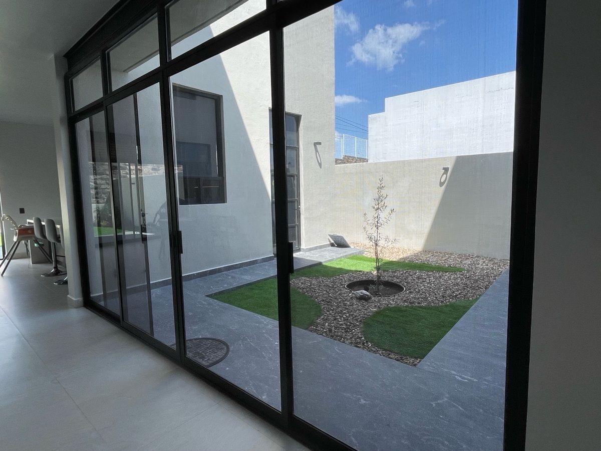 Jardín interior con acceso a pasillo lateral