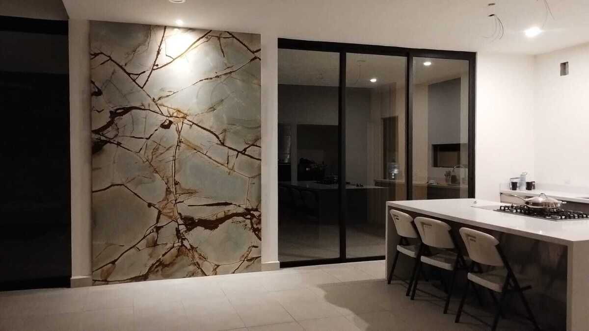 25 de 31: cocina con mesa de cuarzo blanco y pared decorativa