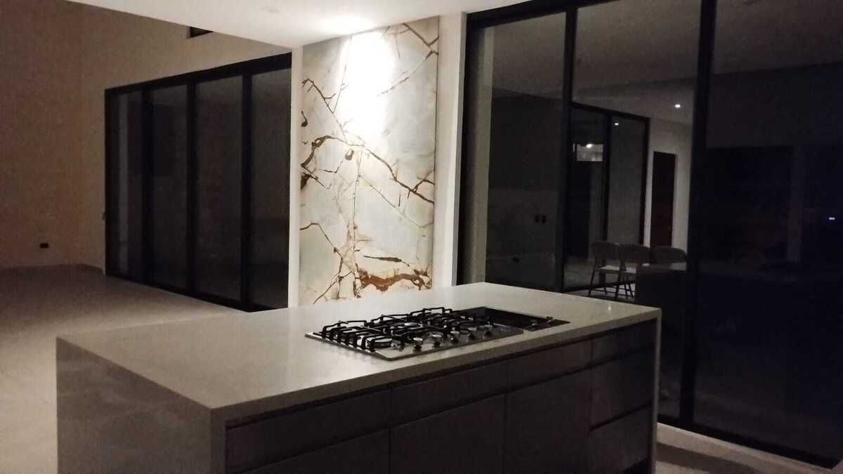 26 de 31: cocina con mesa de cuarzo blanco y pared decorativa