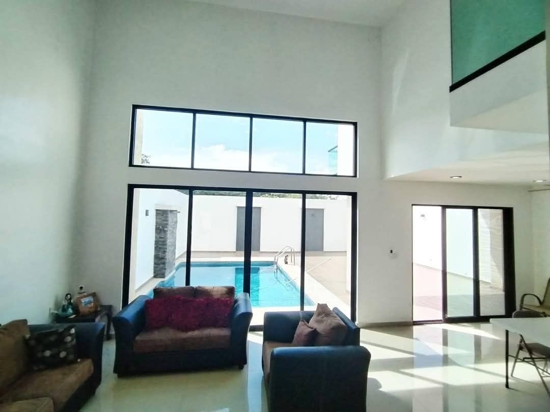 3 de 12: Sala con doble altura y vista hacia la Piscina