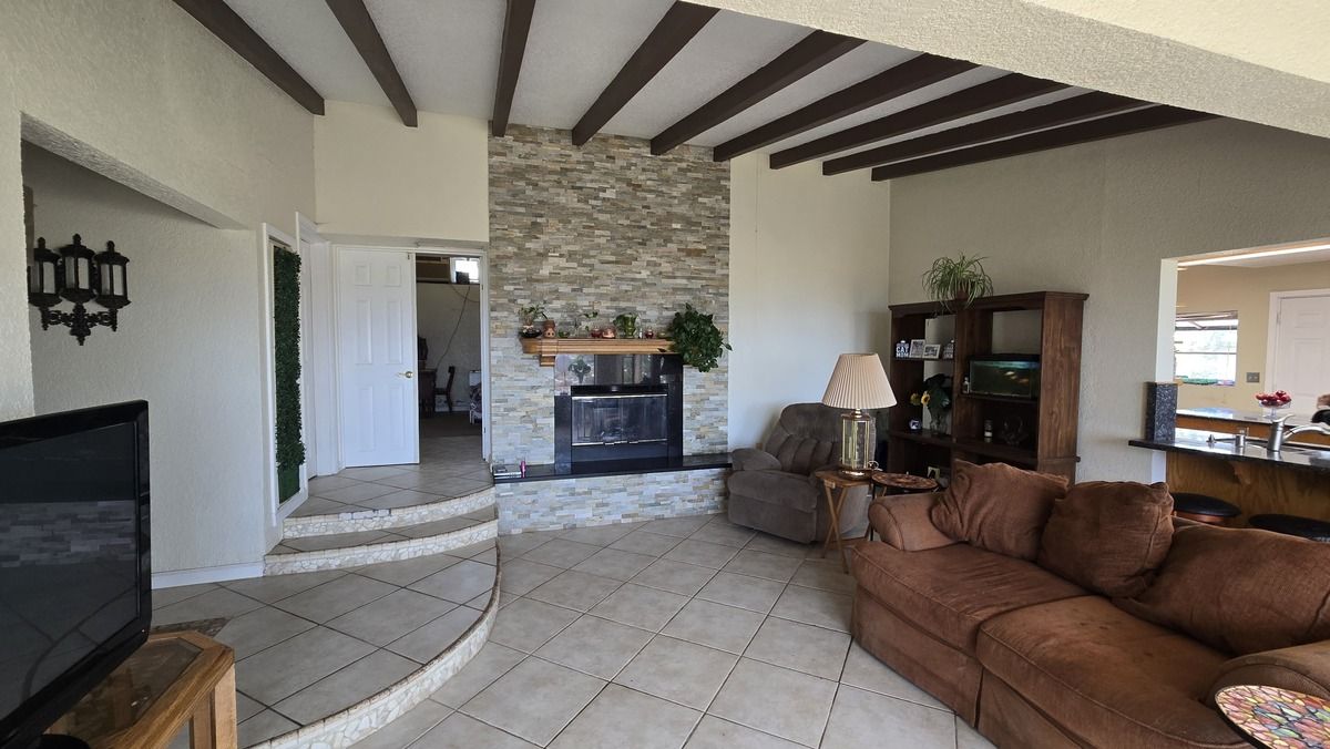 2 of 19: Sala con chimenea y entrada a recamara principal y baño