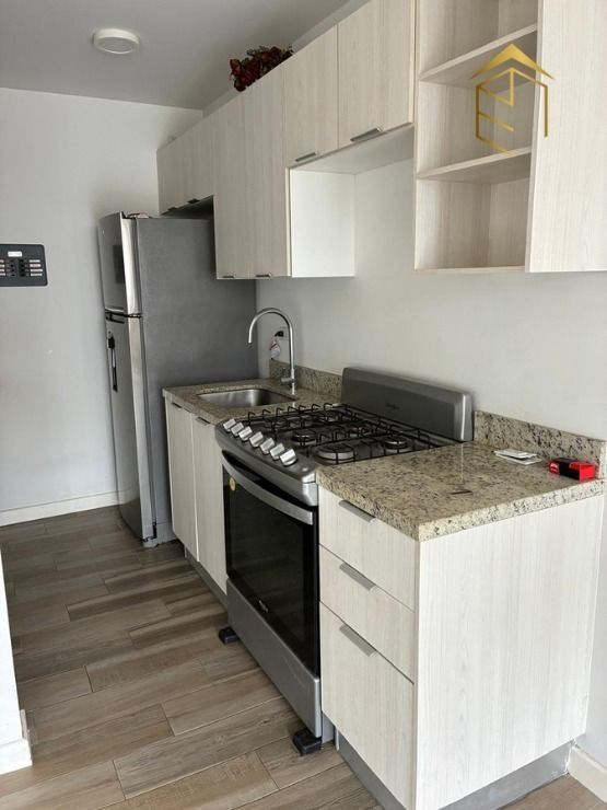 3 de 12: Cocina con estufa y refrigerador