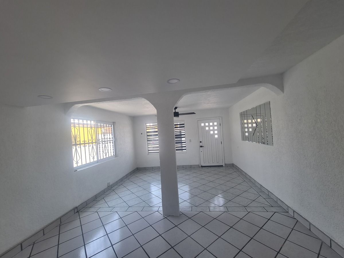 15 de 31: VISTA DE LA SALA Y PUERTA PRINCIPAL DESDE LA COCINA