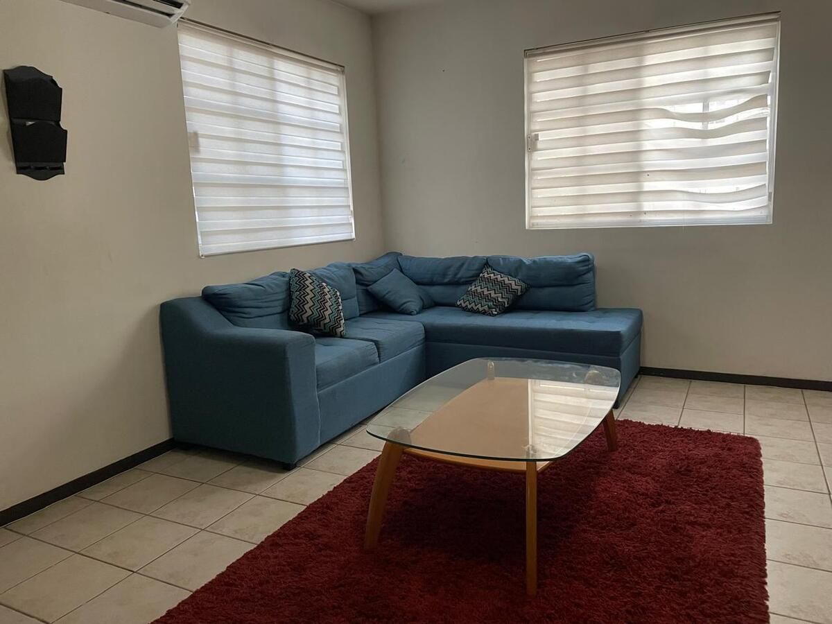 2 de 18: Sala con cojines, tapete, mesa de centro y clima de 2ton.