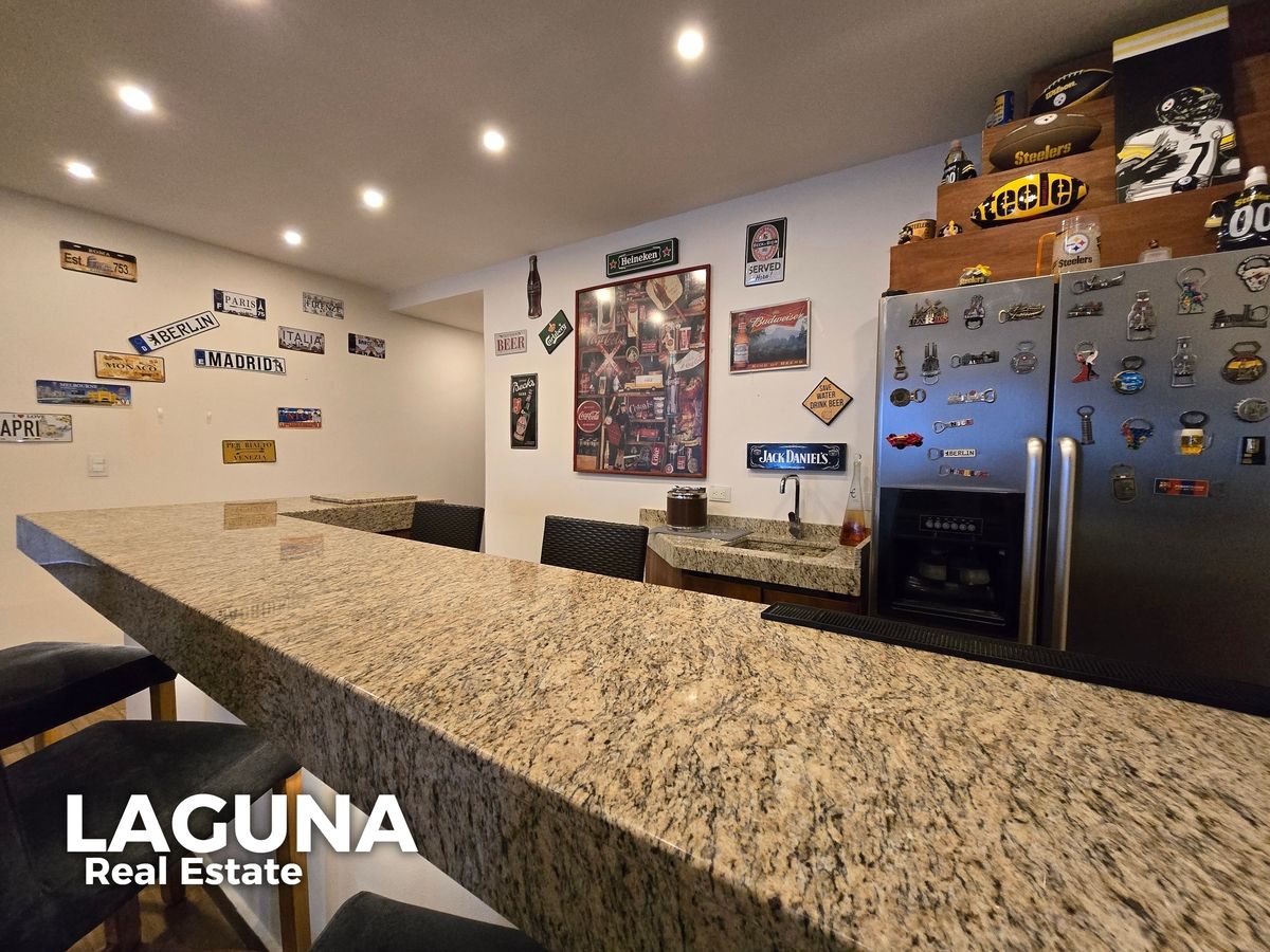 12 of 30: Área de Estar tipo Bar con barra de granito y área de lavabo