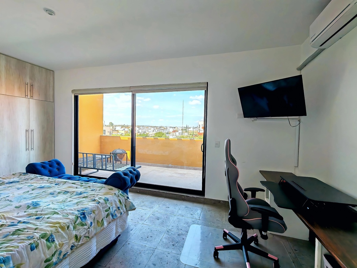 2 of 30: Recamara principal con escritorio y TV