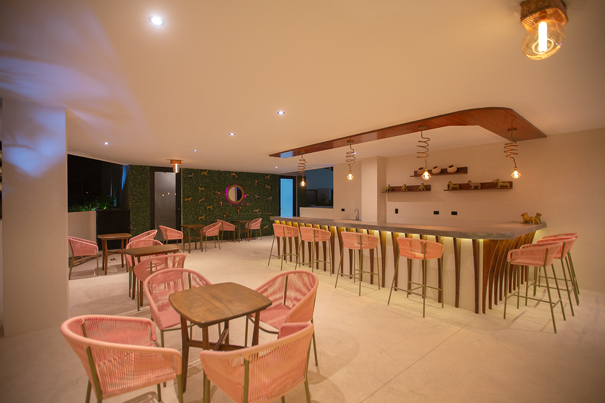 4 de 17: Modern bar with pink chairs and green wall.