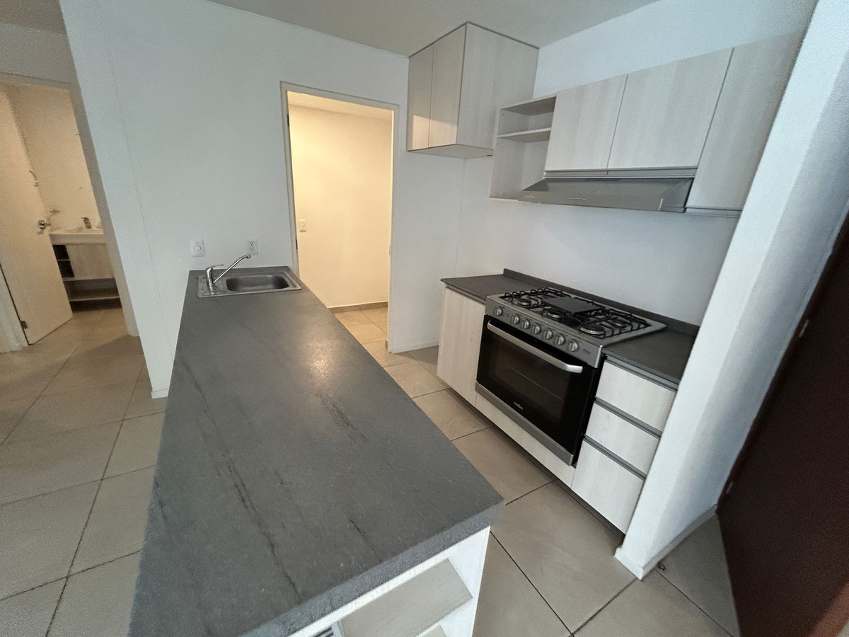 3 of 14: Barra de cocina, a un costado el área de lavado