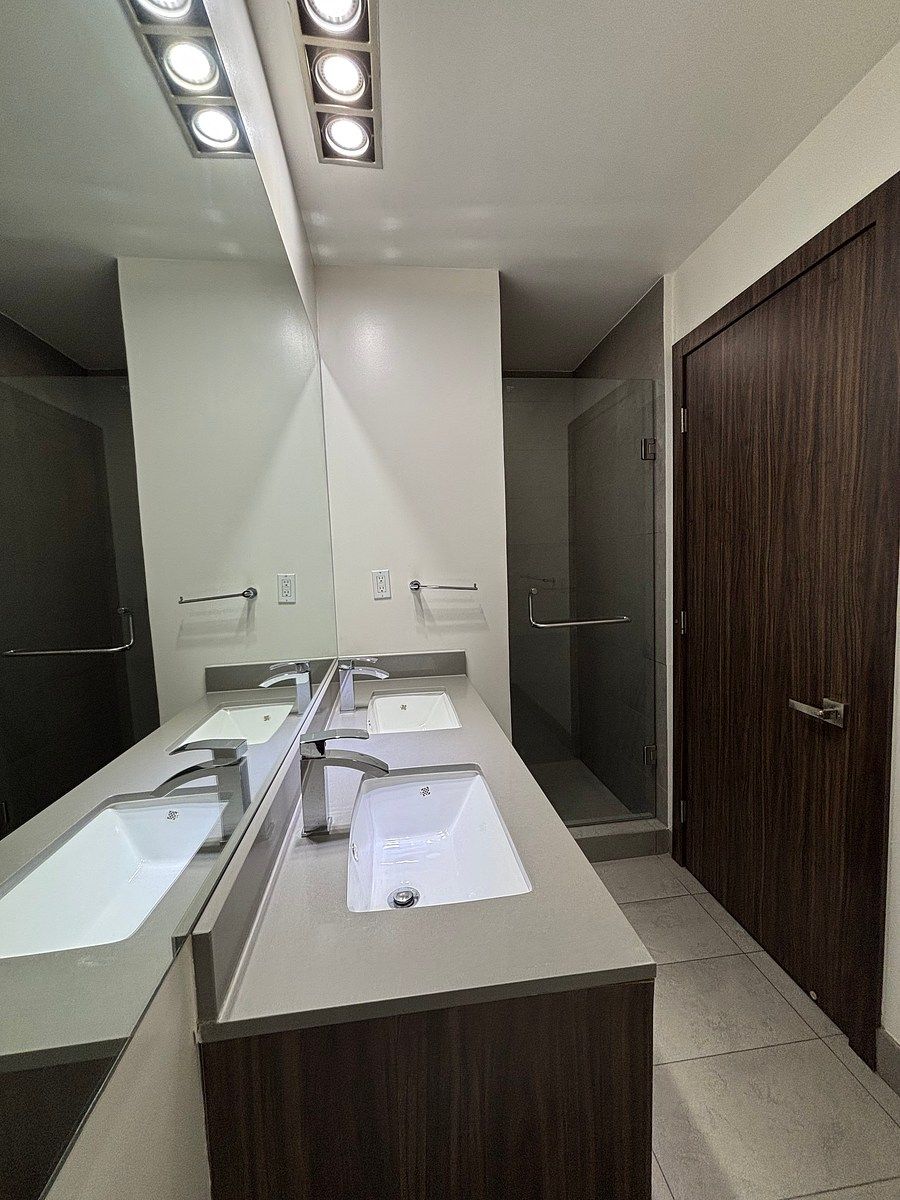23 de 36: Bano con doble lavabo y cancelería de vidrio en regadera