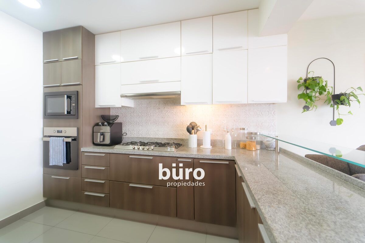 13 de 29: Kitchennette con tablero de granito y torre de hornos.