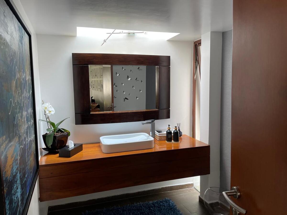 5 of 39: Medio baño de visitas  con mueble empotrado de madera Tzalám