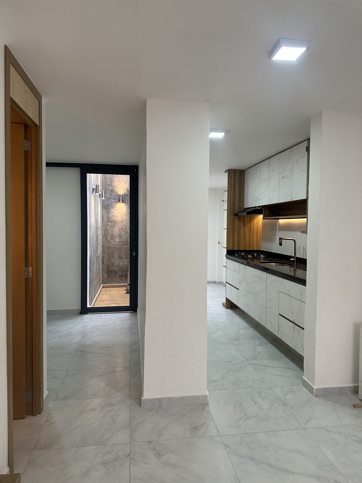 4 of 29: punto focal al ingreso con un muro de cemento pulido