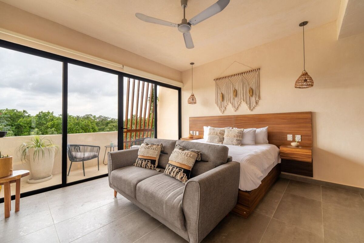 2 de 12: Primary suite with sofa, glass wall, and balcony.