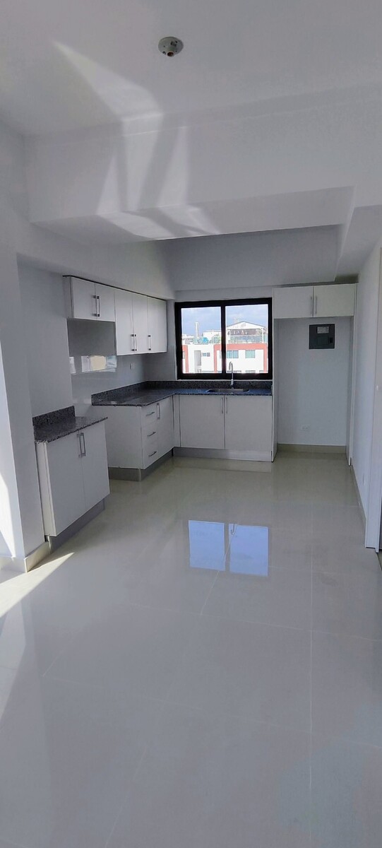 5 de 14: Cocina modular con tope de granito, gabinetes blancos.