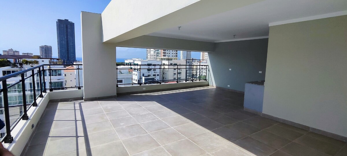 10 de 14: Área social en rooftop con vista al mar y la ciudad.