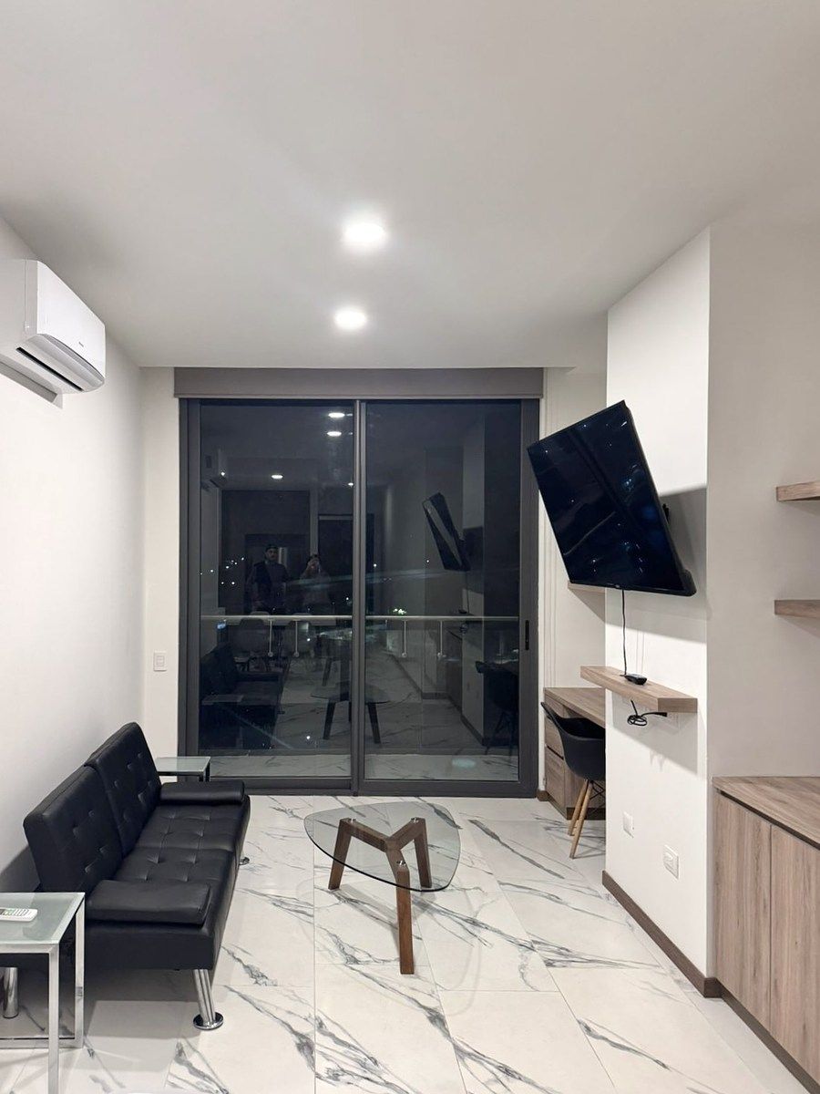 2 de 13: Sala de estar con pantalla y escritorio junto a ventana