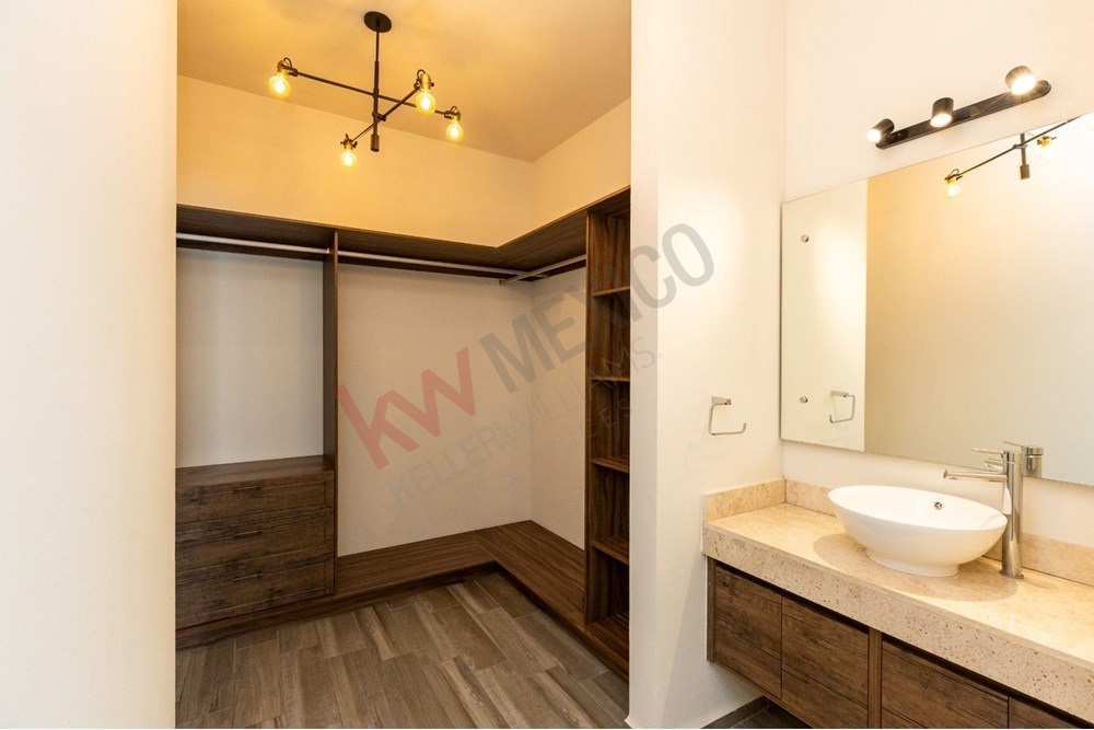 18 of 22: Walk-in closet and primary bath with floating vanity.