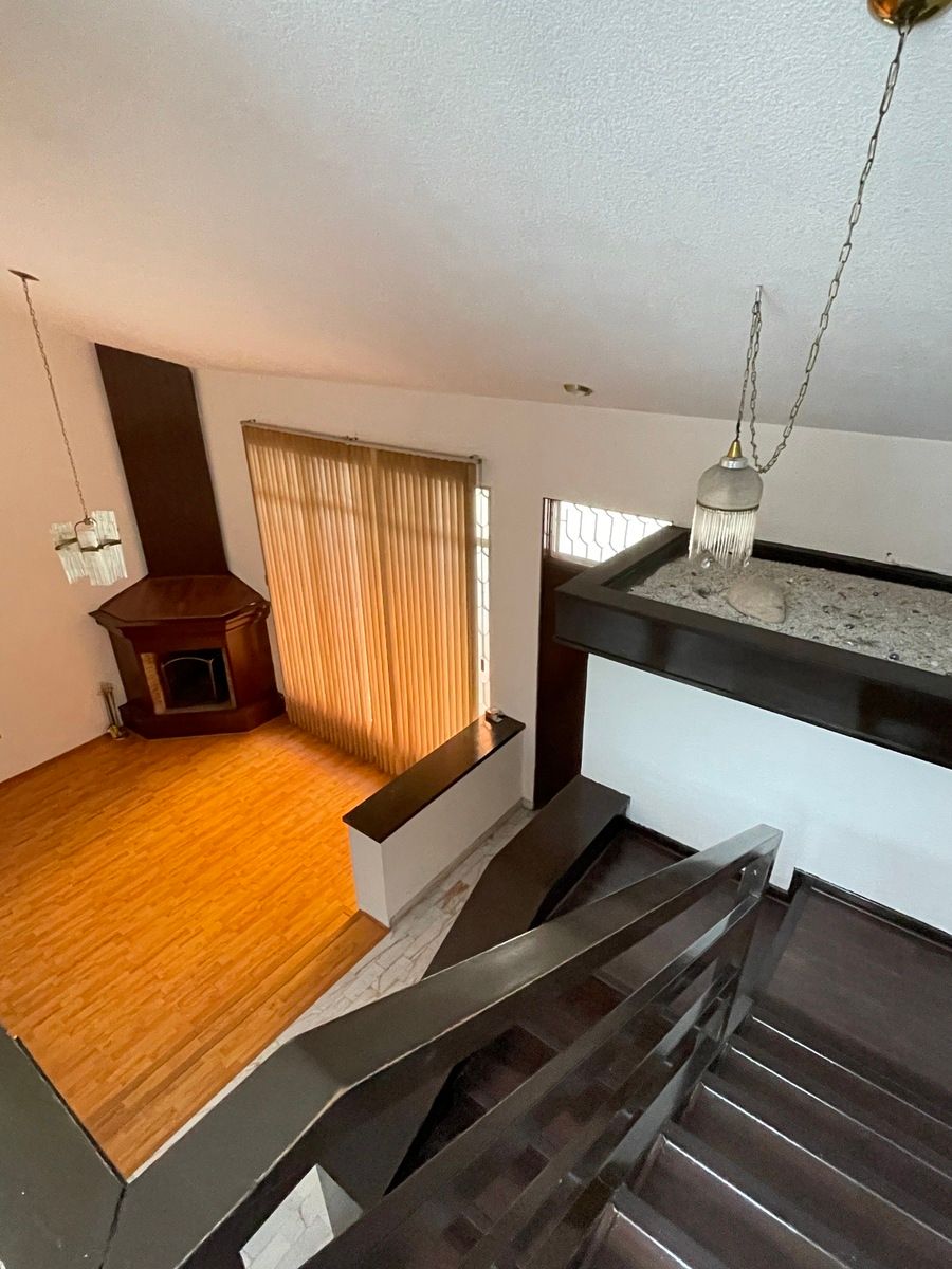 5 of 30: Vista desde las escaleras a la entrada y chimenea de la sala