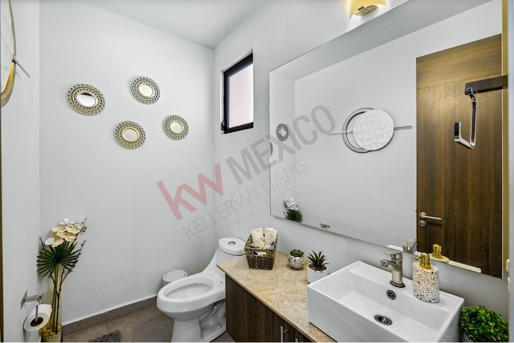 8 of 27: Clean, Modern Bathroom with Vanity and Decorative Mirrors.