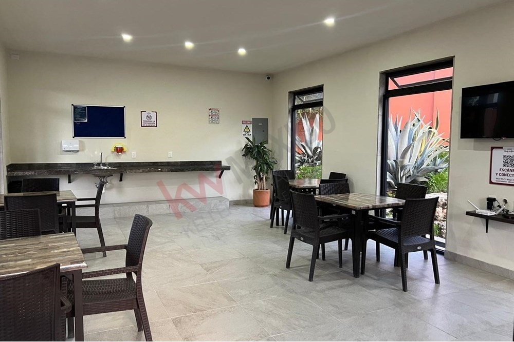 22 of 27: Community Lounge, Tables, Service Bar, Garden Views.