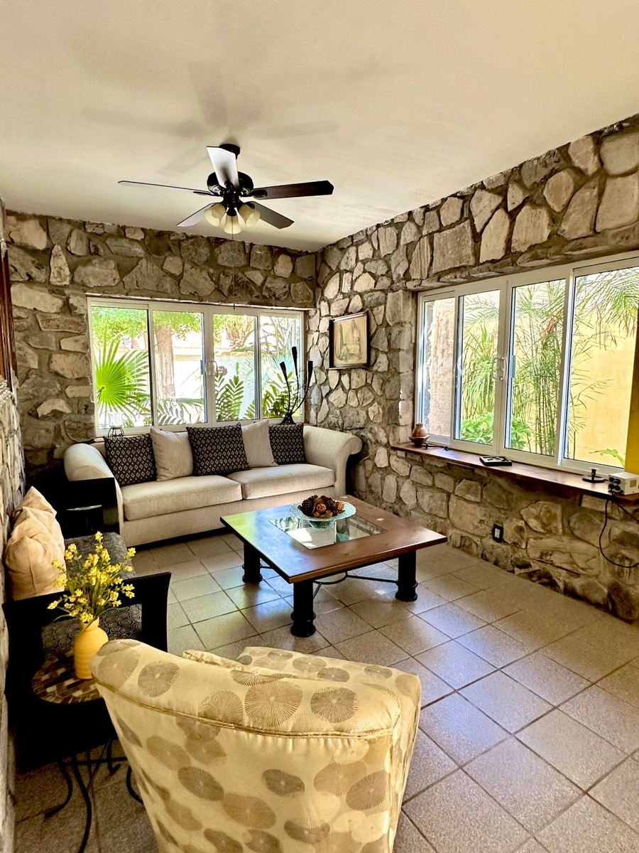 13 de 30: Otro ángulo de sala iluminada y con vistas al jardín.