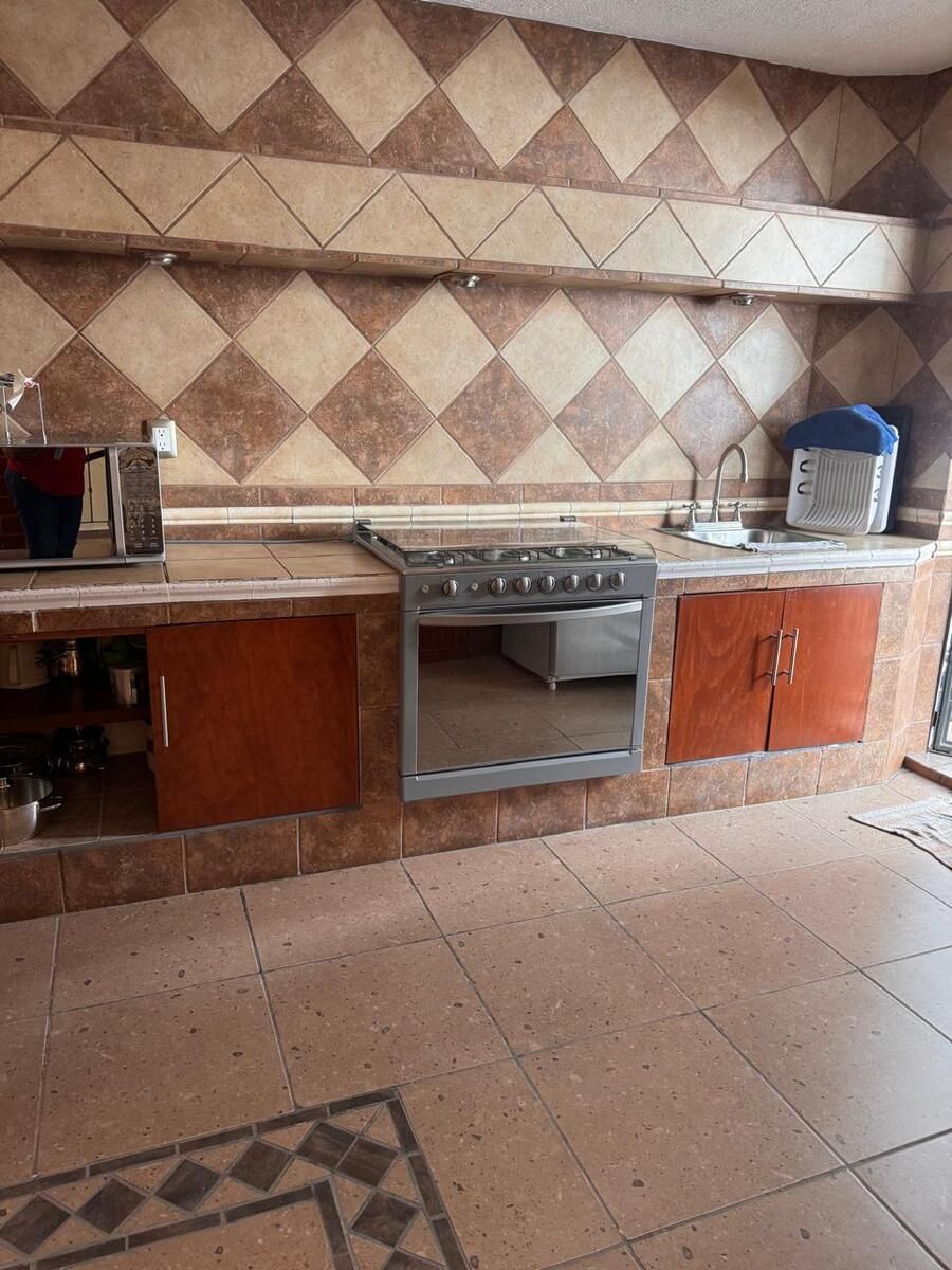 15 de 28: cocina con estufa de 6 quemadores, tarja de acero y puertas.